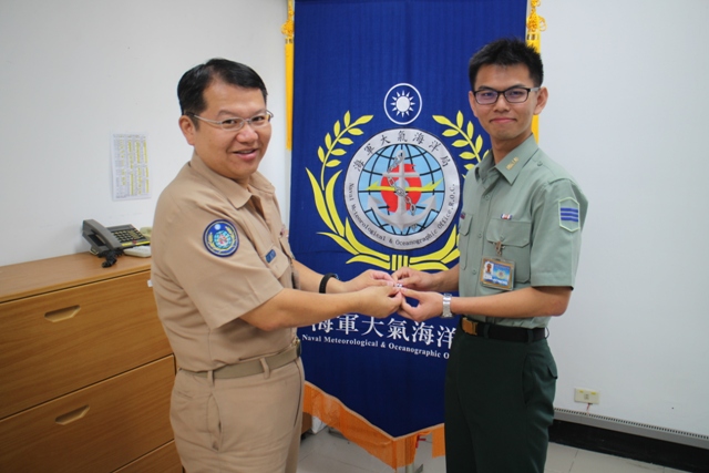 勤務隊長洪國鈞少校將代表測量官科領章傳承給學生楊正宏並給予鼓勵

