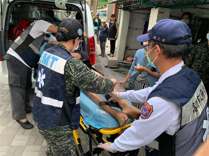 社員協助身體不適長者上救護車送醫治療