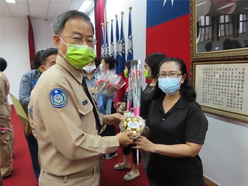 Director Captain Sun presents carnations and heart-shaped chocolates to colleagues. 