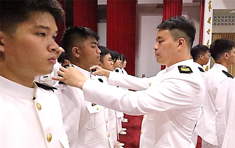 Command Sergeant Major Lo of the Center confers rank to a student.