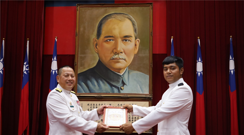 The Deputy Commander of the Naval Education, Training and Doctrine Development Command presents a certificate of academic excellence.